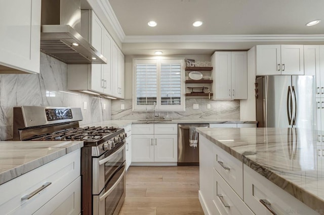 kitchen featuring white cabinets, sink, wall chimney exhaust hood, and appliances with stainless steel finishes