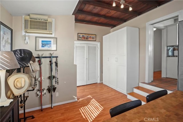 workout area featuring light hardwood / wood-style flooring and wooden ceiling