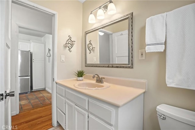 bathroom with vanity, toilet, and wood-type flooring