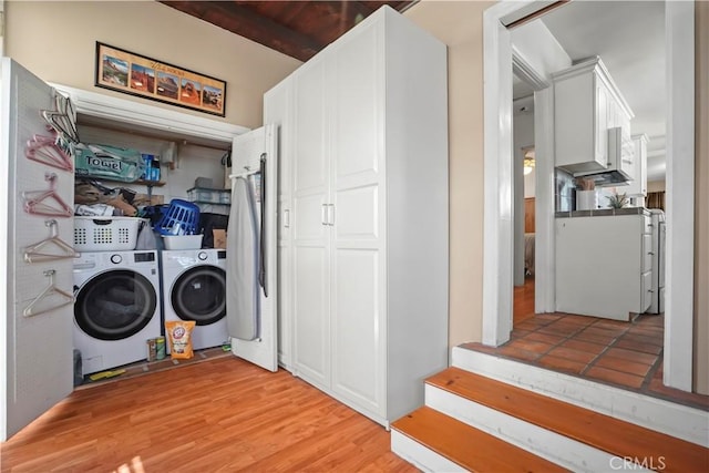 laundry area with separate washer and dryer and light hardwood / wood-style flooring