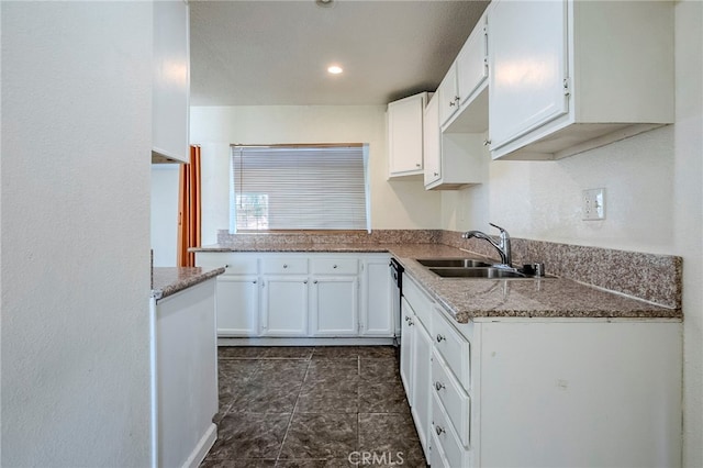 kitchen featuring sink, black dishwasher, white cabinets, and stone countertops