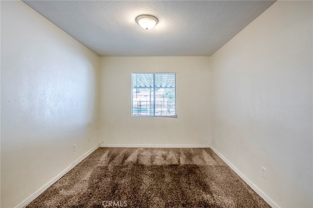 carpeted empty room with a textured ceiling