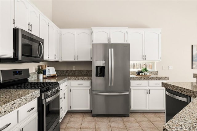 kitchen with white cabinetry, light tile patterned floors, and appliances with stainless steel finishes