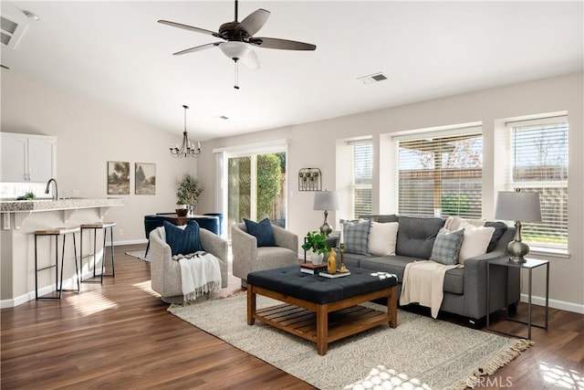 living room featuring dark hardwood / wood-style flooring, sink, ceiling fan with notable chandelier, and lofted ceiling