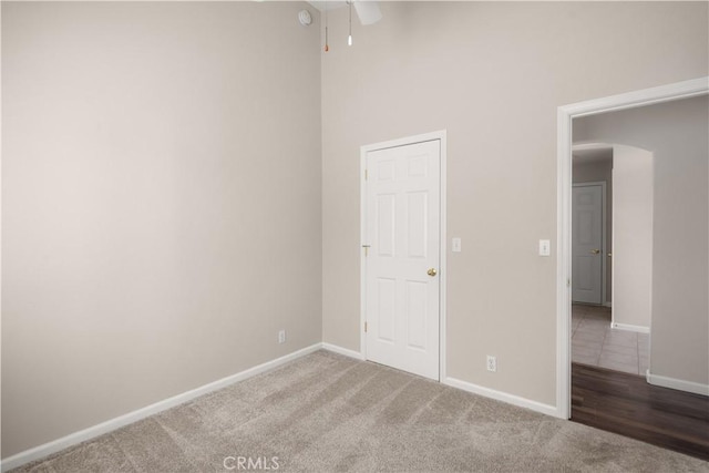 spare room featuring carpet floors and a towering ceiling