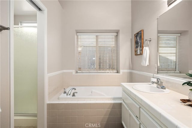 bathroom featuring vanity, independent shower and bath, and a wealth of natural light