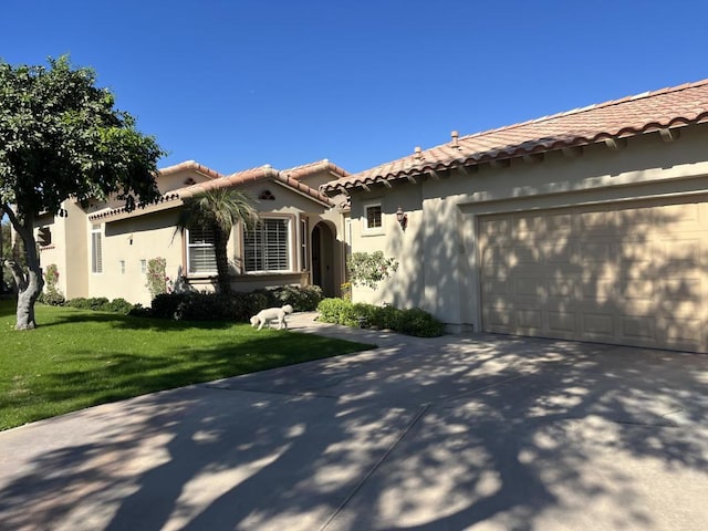 mediterranean / spanish house with a garage and a front lawn