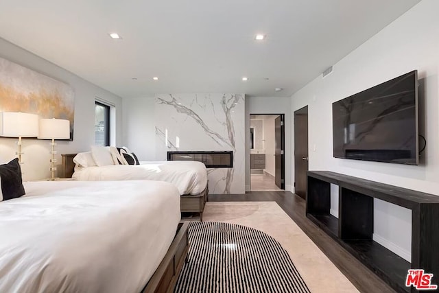 bedroom featuring dark hardwood / wood-style floors and connected bathroom