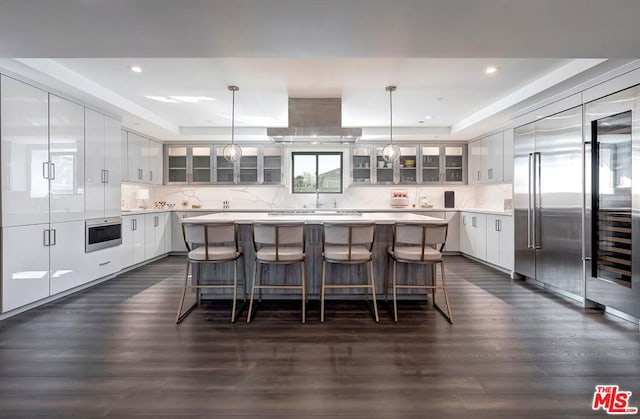 kitchen featuring pendant lighting, a raised ceiling, and a kitchen island