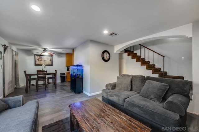 living room featuring ceiling fan and dark hardwood / wood-style floors