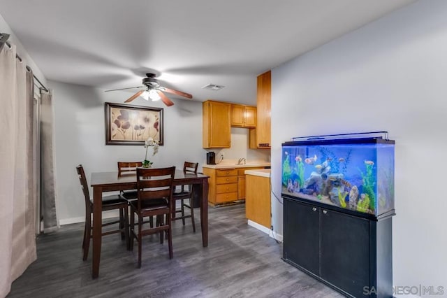 dining room with ceiling fan and dark hardwood / wood-style floors