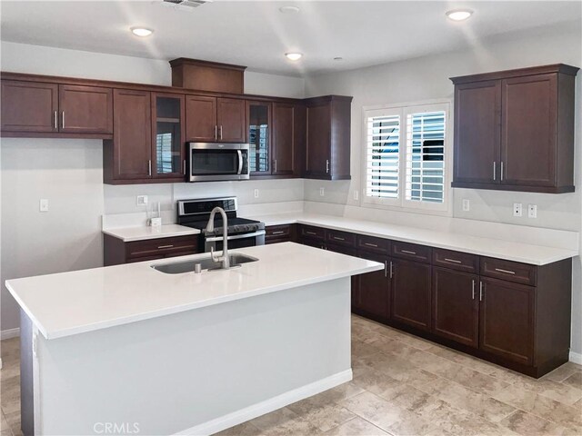 kitchen with a kitchen island with sink, sink, and stainless steel appliances