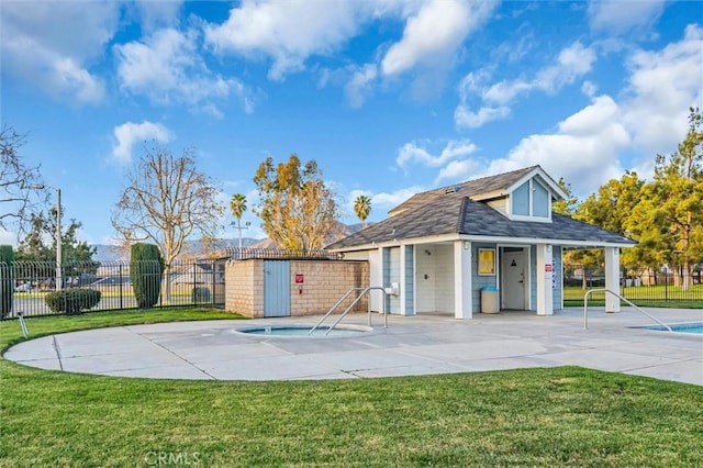 rear view of property featuring a patio, a lawn, and a storage unit