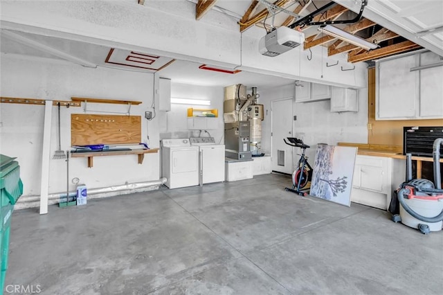 garage featuring heating unit, a garage door opener, and washing machine and clothes dryer