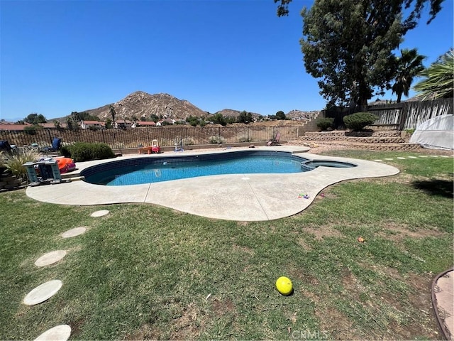 view of swimming pool with a mountain view, a patio area, and a lawn