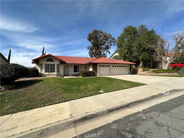 view of front facade featuring a tile roof, concrete driveway, a front yard, stucco siding, and a garage