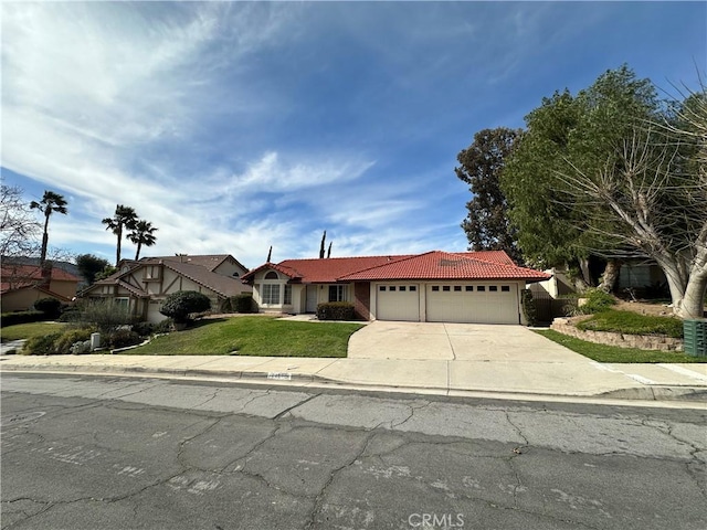 view of front of home with a garage, driveway, a front yard, and a tiled roof