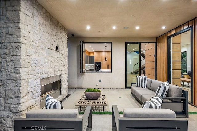 living room with wood walls and an outdoor stone fireplace