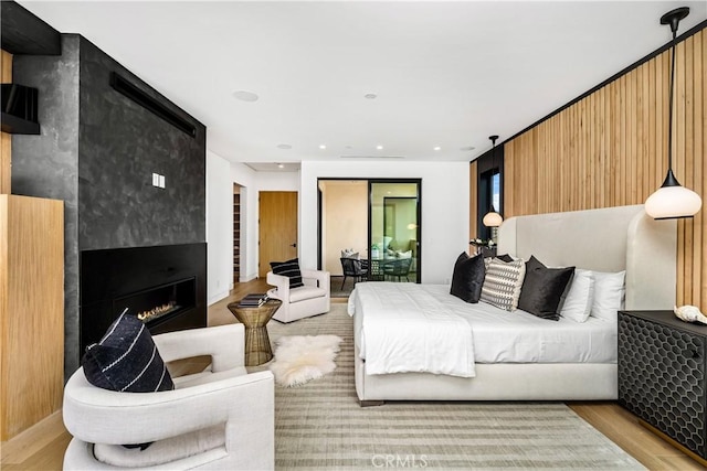 bedroom featuring a large fireplace and light wood-type flooring