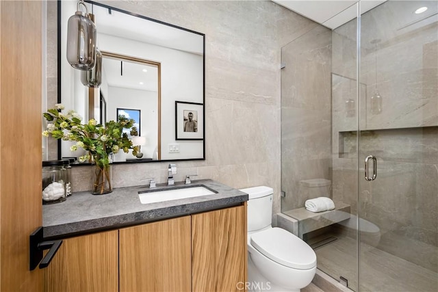 bathroom with tile walls, backsplash, toilet, walk in shower, and vanity