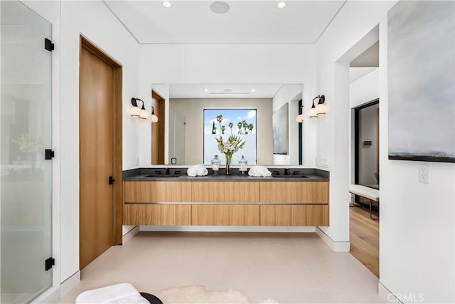 bathroom with a shower with shower door and vanity