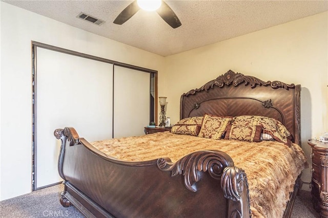 carpeted bedroom featuring a textured ceiling, a closet, and ceiling fan