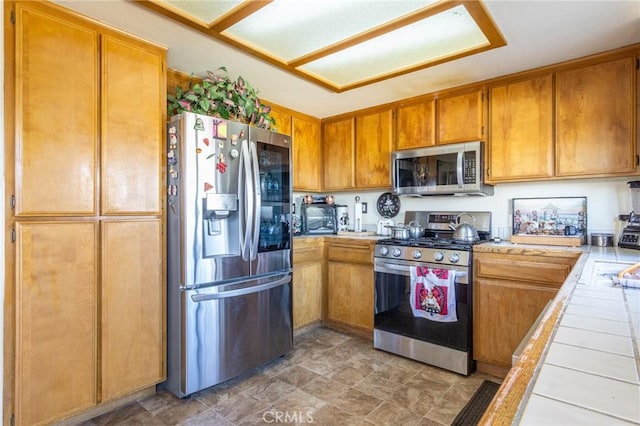 kitchen featuring stainless steel appliances and tile counters