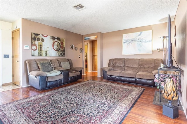 living room featuring hardwood / wood-style flooring and a textured ceiling