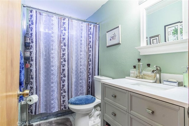 bathroom with tile patterned flooring, vanity, and toilet