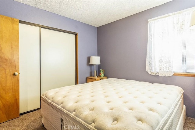 carpeted bedroom featuring a closet and a textured ceiling