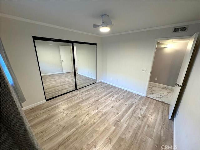 unfurnished bedroom with light hardwood / wood-style flooring, a closet, and ornamental molding