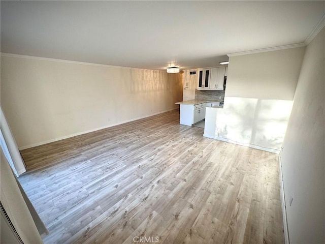 unfurnished living room featuring light hardwood / wood-style flooring and crown molding