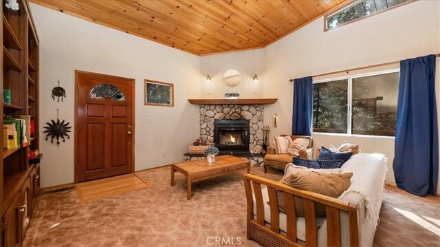 carpeted living room featuring a stone fireplace and wood ceiling