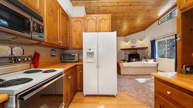 kitchen featuring a stone fireplace, white appliances, wood ceiling, light hardwood / wood-style flooring, and lofted ceiling