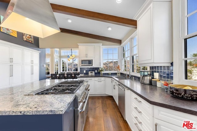 kitchen featuring appliances with stainless steel finishes, white cabinetry, decorative backsplash, sink, and dark wood-type flooring