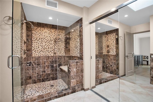 bathroom featuring a skylight and an enclosed shower