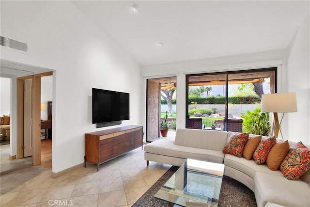 living room featuring high vaulted ceiling and light tile patterned floors