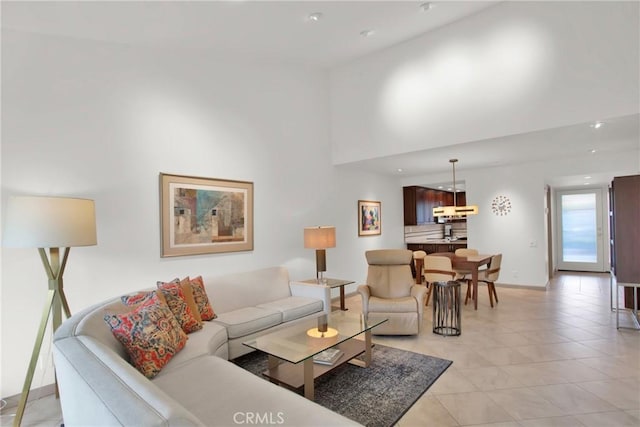 living room with light tile patterned flooring and a towering ceiling