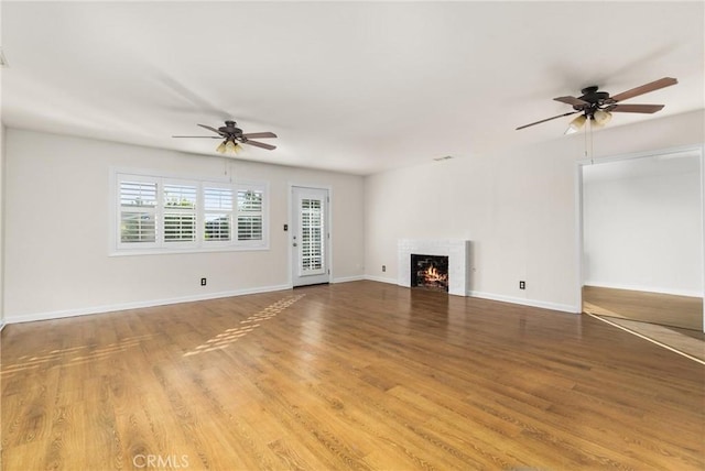 unfurnished living room with wood-type flooring and ceiling fan