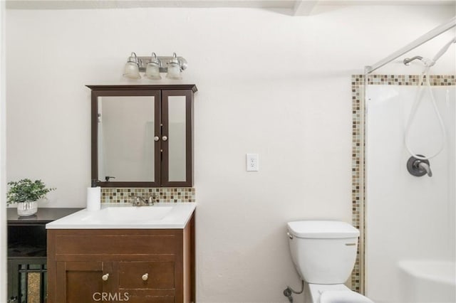 bathroom with tasteful backsplash, vanity, a shower, and toilet