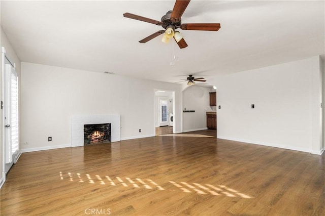 unfurnished living room with hardwood / wood-style flooring and ceiling fan