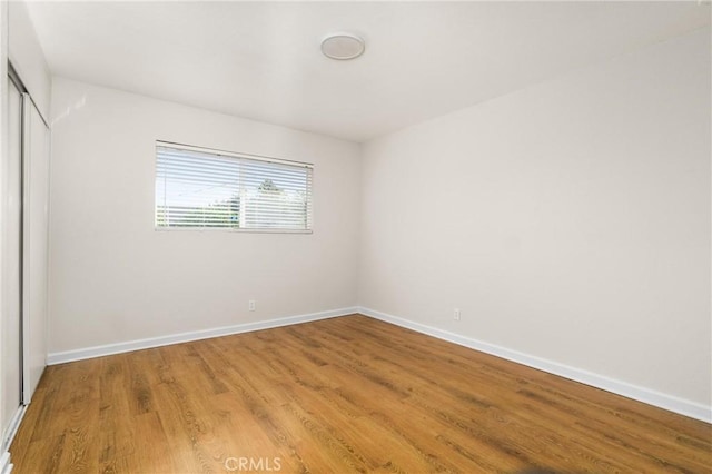 unfurnished bedroom featuring wood-type flooring and a closet