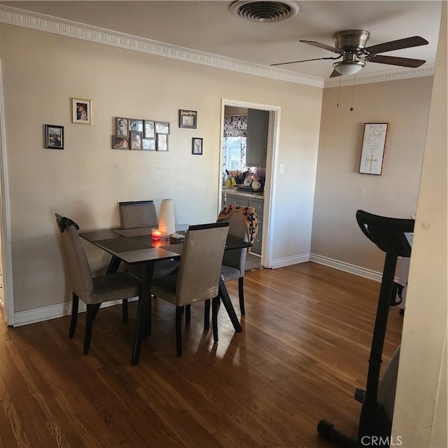 dining space with dark wood-type flooring, ornamental molding, and ceiling fan