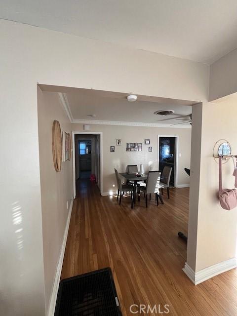 corridor with hardwood / wood-style flooring and crown molding