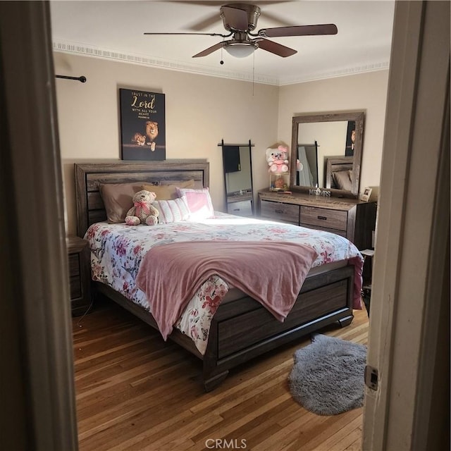 bedroom featuring crown molding, hardwood / wood-style floors, and ceiling fan