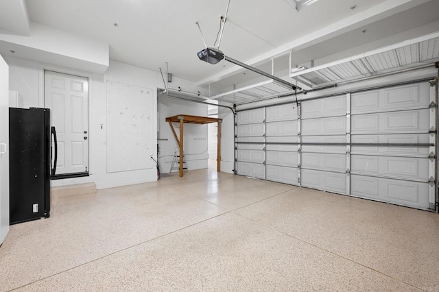 garage featuring black refrigerator and a garage door opener