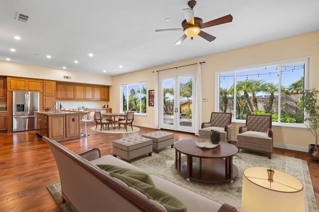 living room featuring hardwood / wood-style flooring, ceiling fan, plenty of natural light, and sink