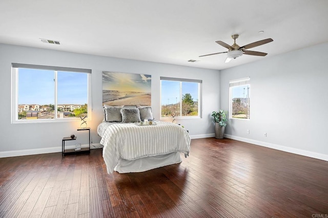 bedroom with dark hardwood / wood-style flooring and ceiling fan