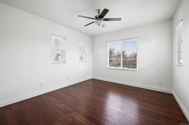 empty room with ceiling fan, a wealth of natural light, and dark hardwood / wood-style flooring