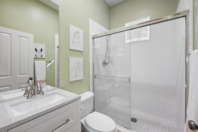 bathroom with an enclosed shower, vanity, and toilet